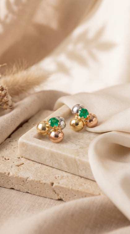 Topos en oro combinado 18K con diseño de esferas y esmeralda